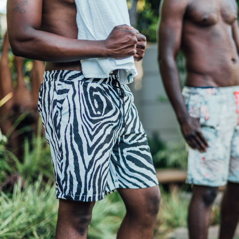 A man wearing casual shorts with a zebra skin pattern on them in a garden